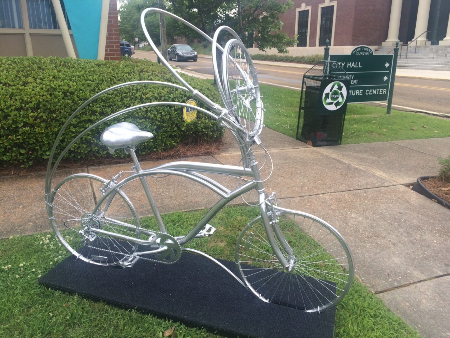 A bicycle sculpture is on display in the grass.